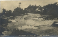 The old works from an early postcard. Water was a problem in the mines which partly explains the windpump over an old shaft.