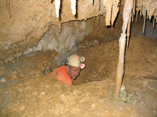 Crawling into a decorated passage in Matienzo, Spain